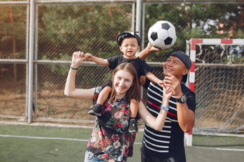 Image of the people we help: a child, a teen, and and adult playing on a soccer field